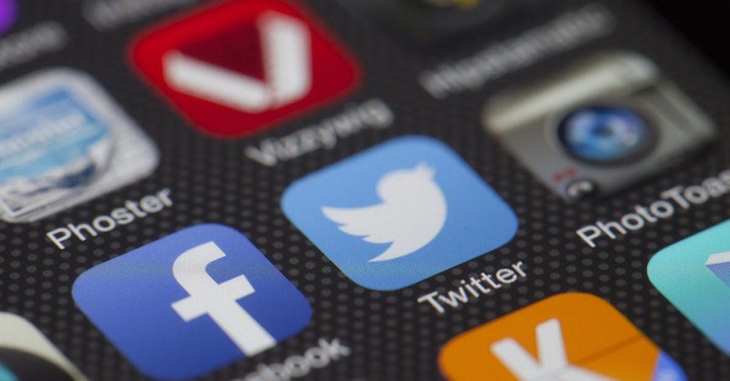 A detailed close-up of social media icons on a smartphone screen, including Facebook and Twitter.